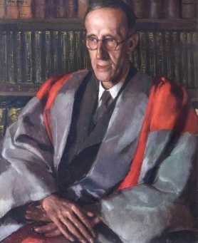 Portrait of Sir Frank Stenton in academic gown with a backdrop of bookshelves.